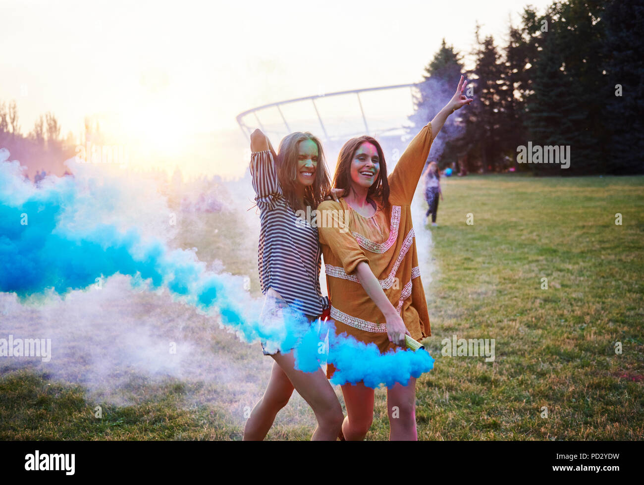 Due giovani donne che danzano con fumo blu bombe di Holi festival Foto Stock