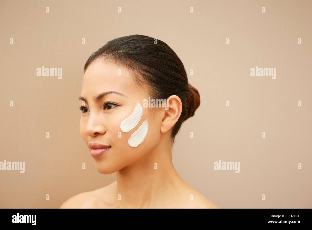 Donna con tracce di colore bianco sulla guancia Foto Stock