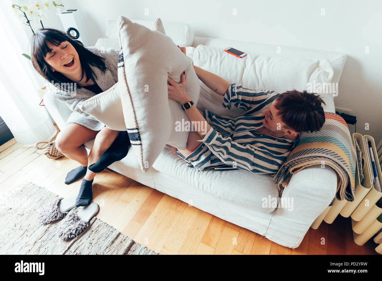 Le donne di combattimento di cuscini sul divano, ad alto angolo di visione Foto Stock