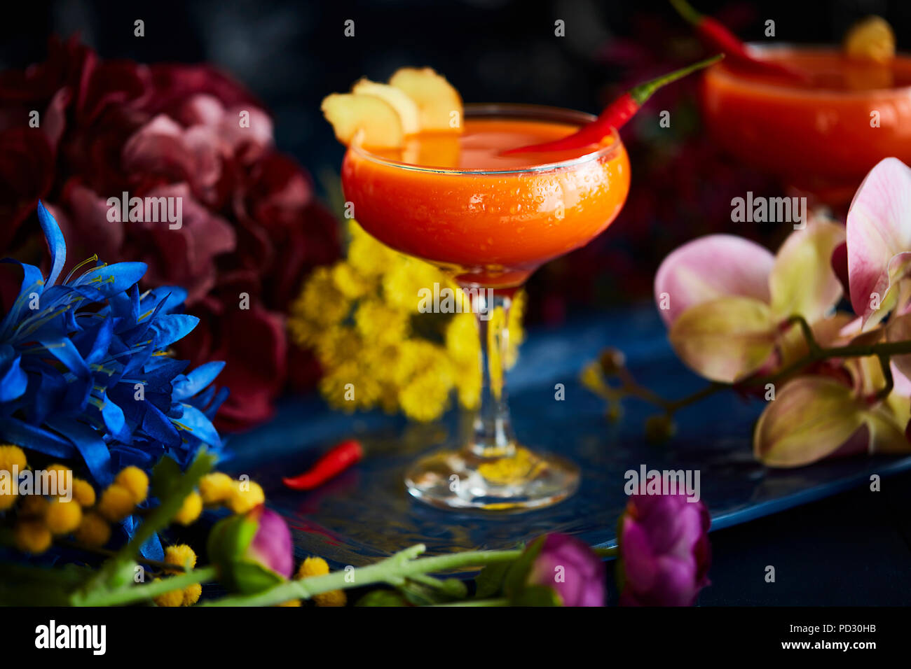 Cocktail condito con peperoncino rosso e fette di zenzero Foto Stock