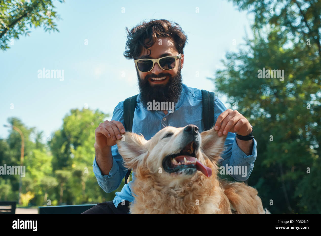 Uomo e cane divertendosi, giocando, facendo facce buffe mentre restin Foto Stock