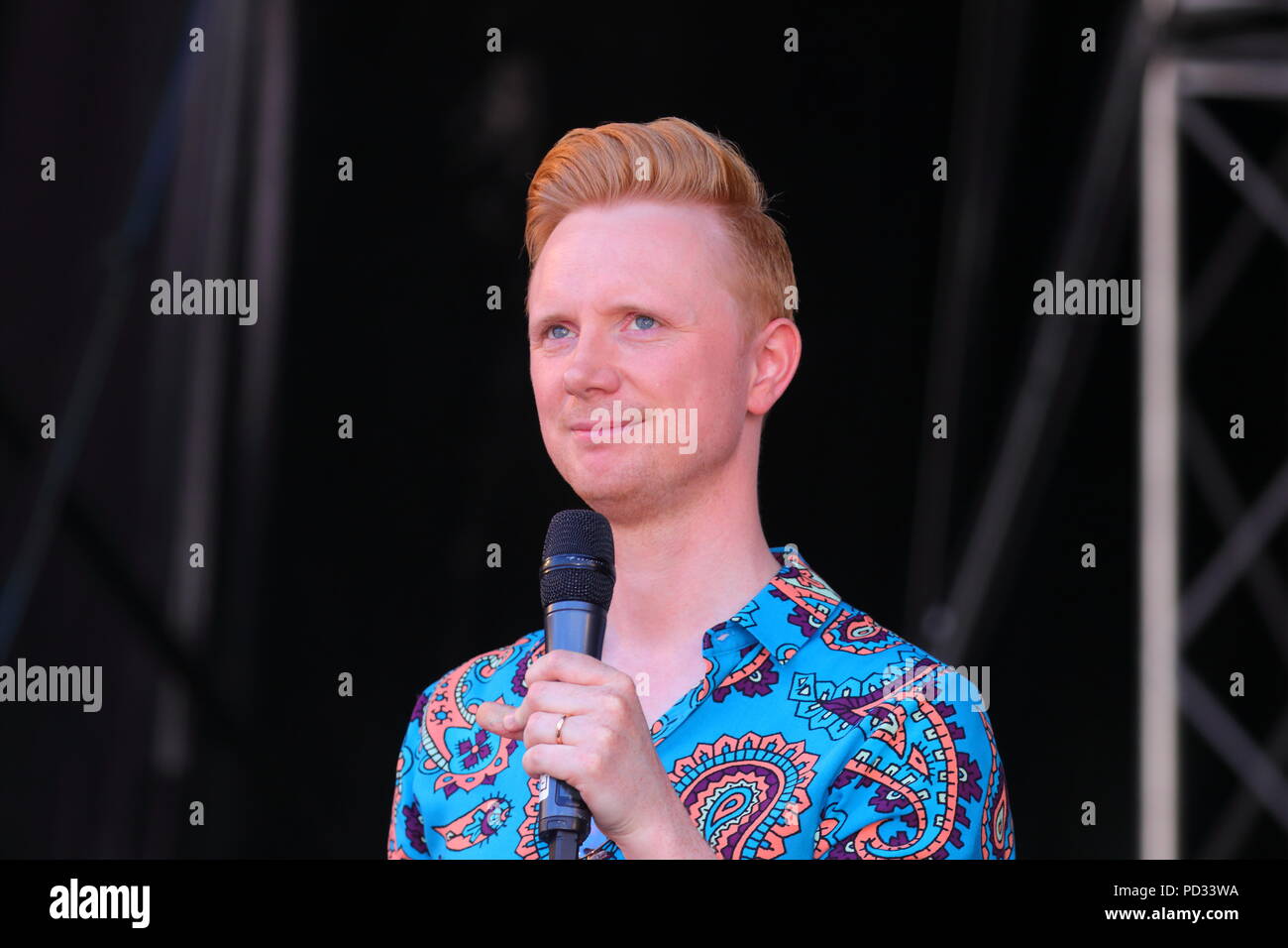 Owain Wyn Evans che ospita il Leeds LGBT Pride 2018 Sul palco al Millennium Square a Leeds Foto Stock