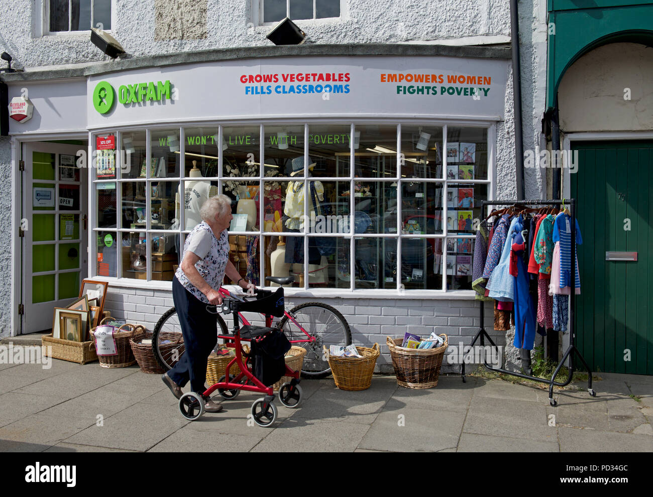 Senior donna al di fuori di Oxfam carità shop, England Regno Unito Foto Stock