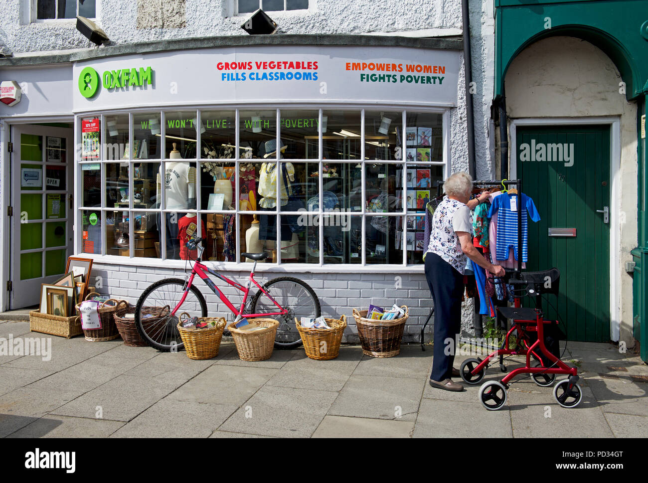Senior donna al di fuori di Oxfam carità shop, England Regno Unito Foto Stock