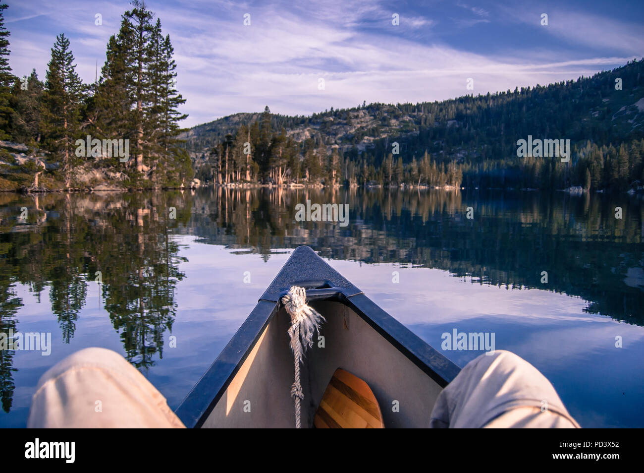 Uomo in canoa sul Lago di Echo, prospettiva personale, alta Sierras, CALIFORNIA, STATI UNITI D'AMERICA Foto Stock