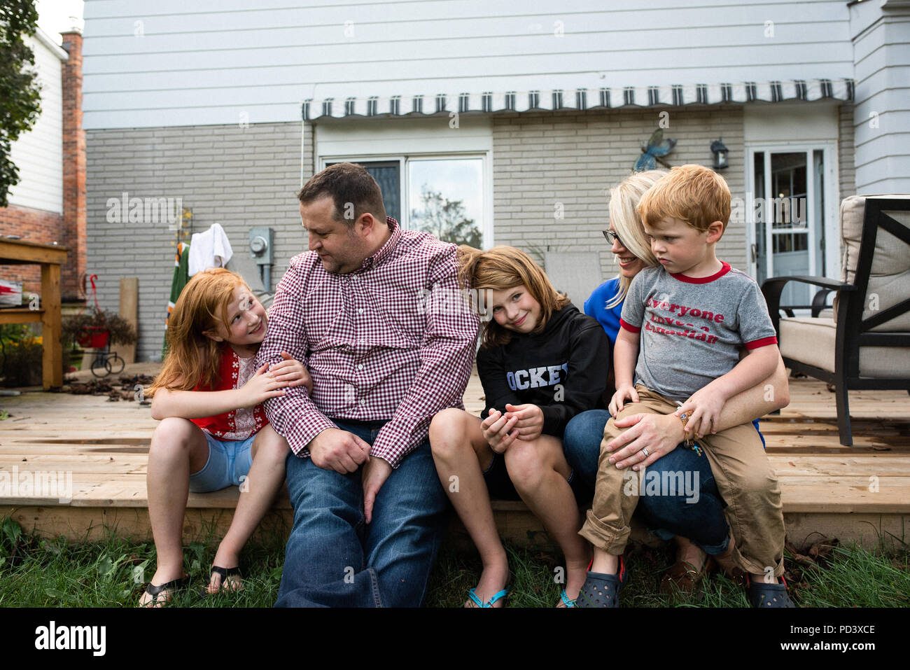 Famiglia di cinque persone sulla terrazza giardino Foto Stock