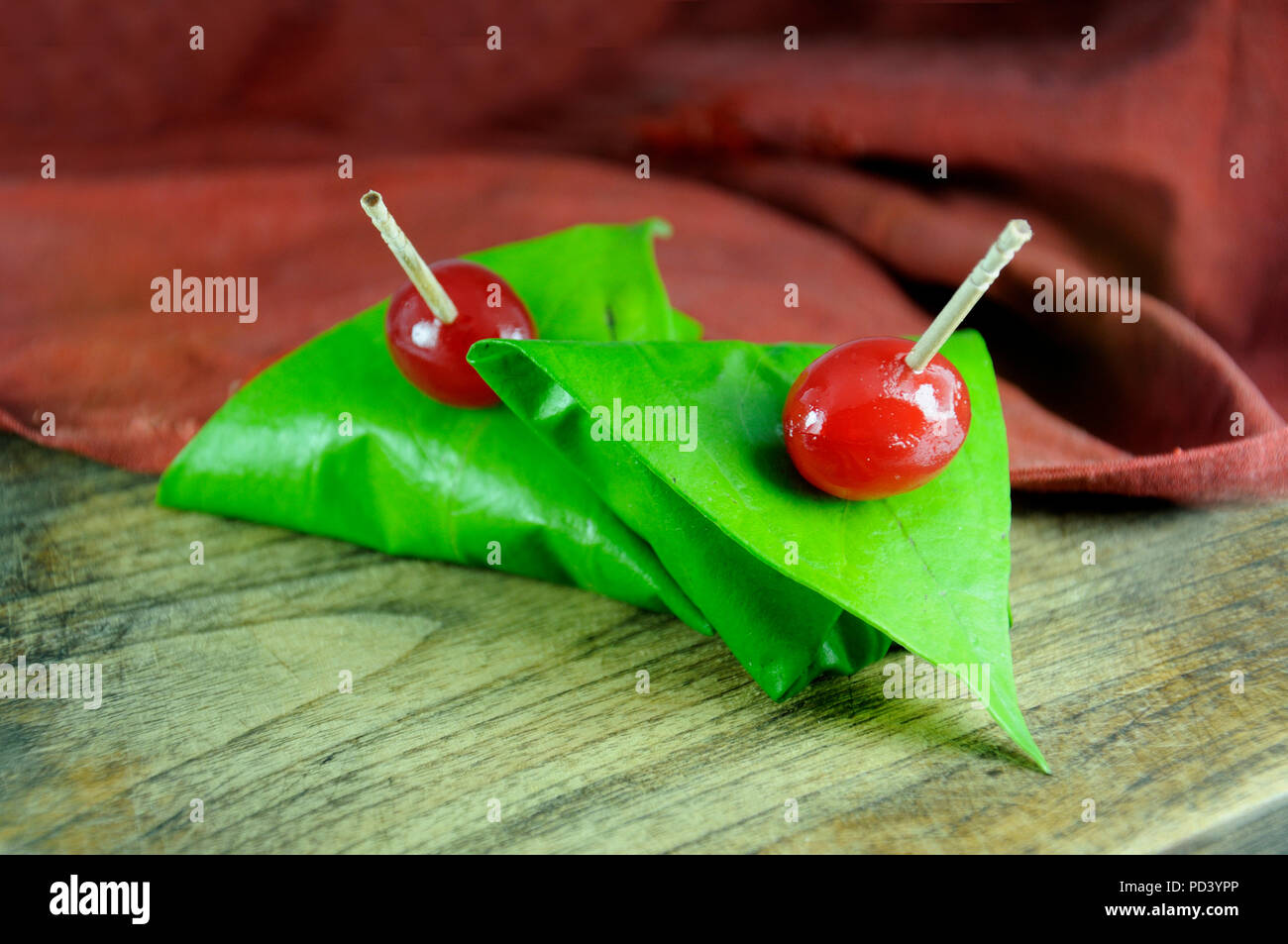 Dolce paan avvolto in foglie di betel, spesso usato come digestivi del dopo cena. Foto Stock