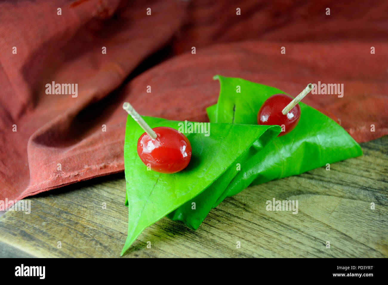 Dolce paan avvolto in foglie di betel, spesso usato come digestivi del dopo cena. Foto Stock