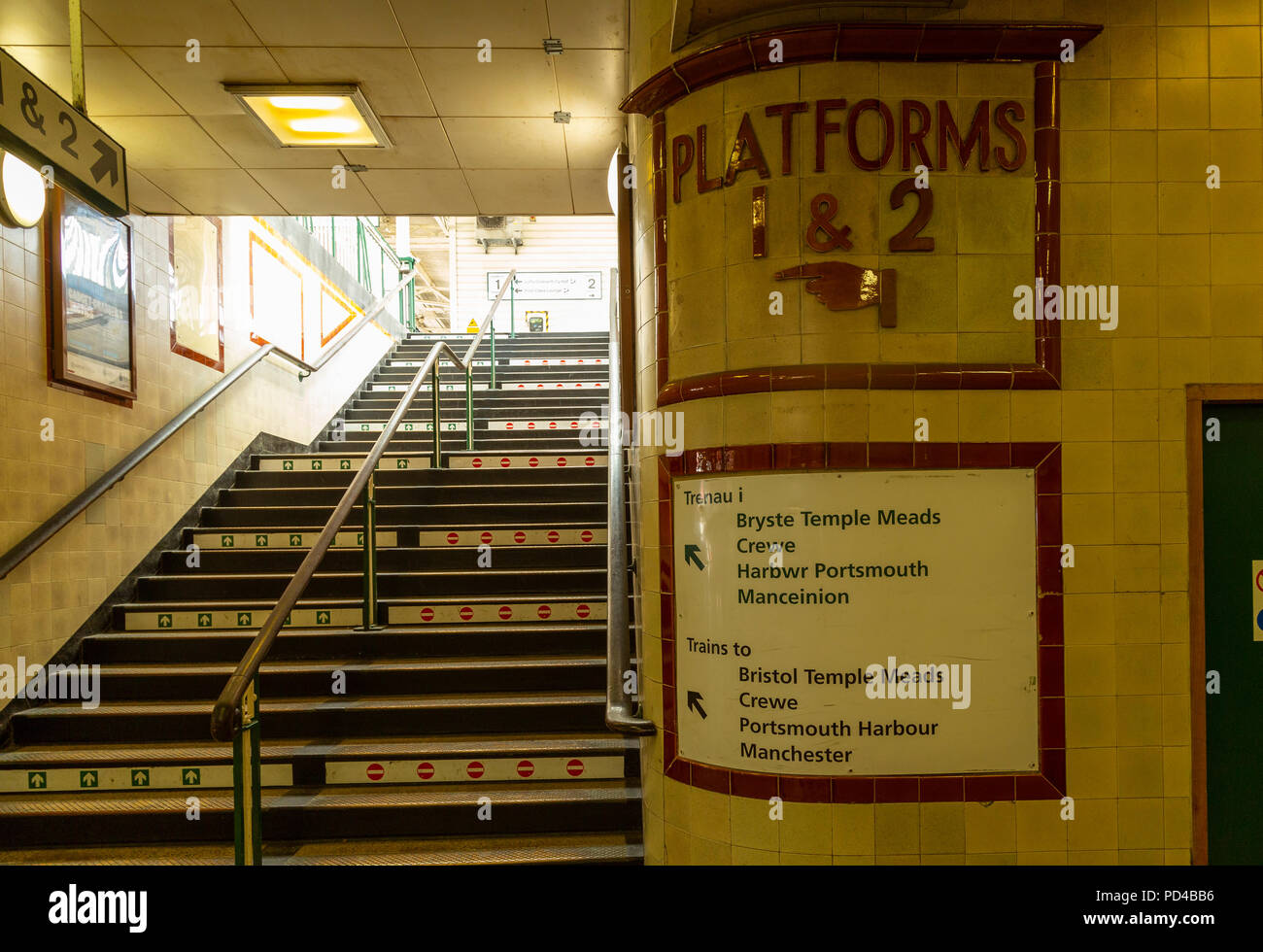 La Stazione Centrale di Cardiff, Galles. gradini che portano dal sottopassaggio tunnel per piattaforme, con vecchi segni piastrellato. Foto Stock