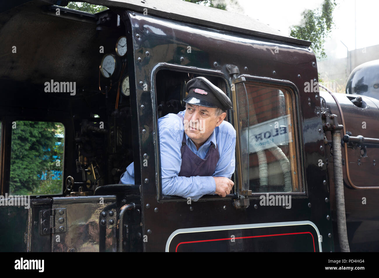 Driver del motore sulla pedana di No.78018 Ferrovie britanniche Standard Classe 2 locomotiva a vapore e guardando fuori della cabina Foto Stock