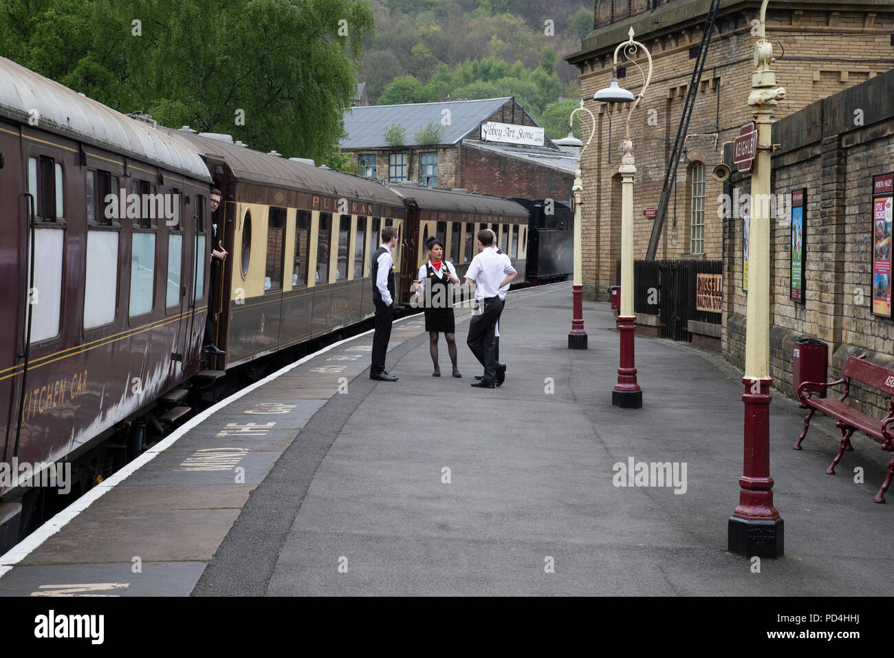 Stazione personale del ristorante e amministratori sulla piattaforma accanto al Pullman di lusso trasporto ferroviario sul Keighley & Worth Valley Railway Foto Stock