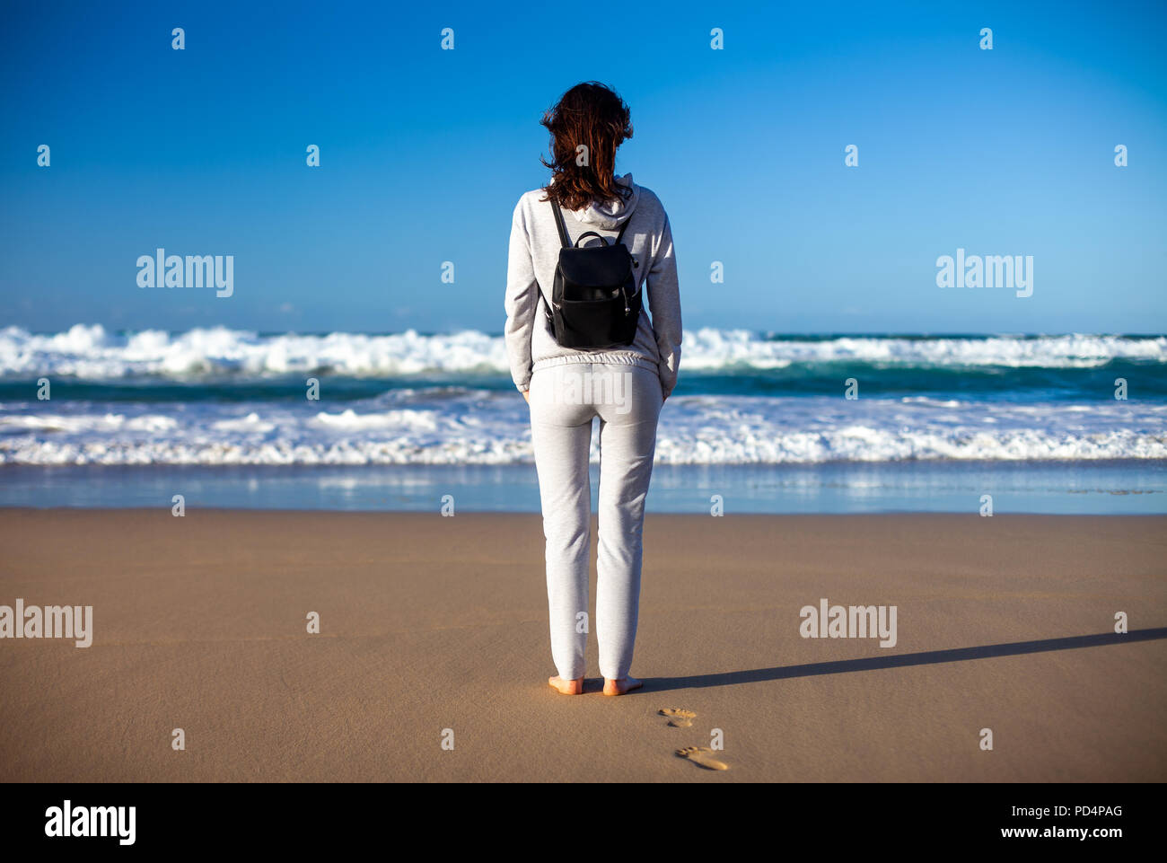 Full lenght Ritratto di giovane donna godere di ocean sulla spiaggia, Isole canarie, Spagna. Concetto di viaggio Foto Stock