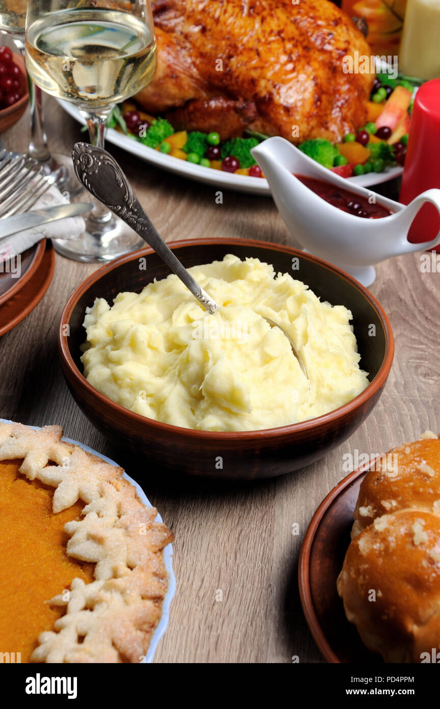 Una tazza di purea di patate su una tabella tra la torta di zucca cotta in Turchia, mirtillo rosso-arancio di salsa, un bicchiere di vino bianco per il giorno del Ringraziamento Foto Stock
