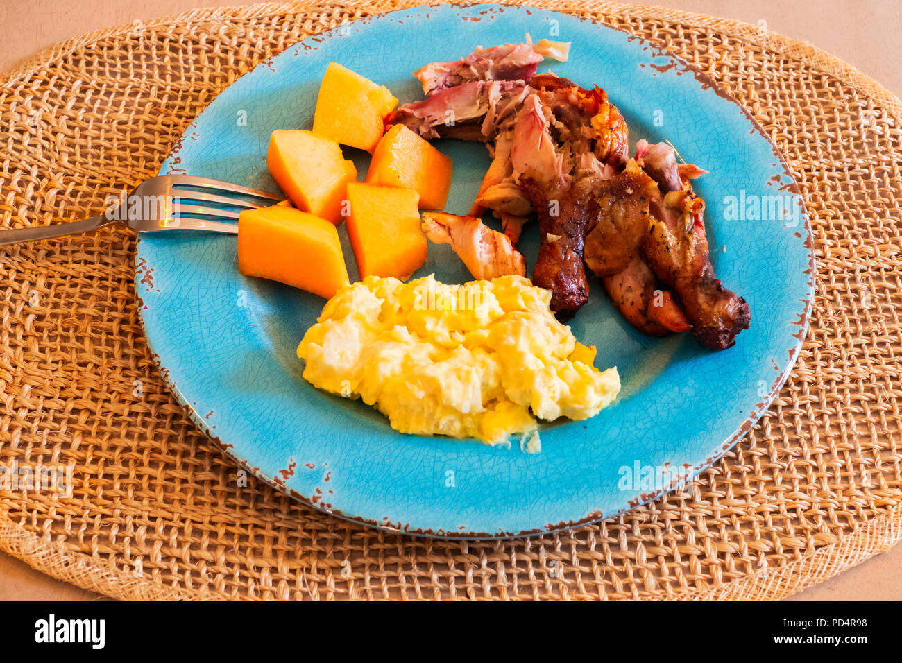 Una piastra di aqua con un serving di grigliate di pollo spatchcocked, insalata di patate e canteloupe su un posto di mat, guardando verso il basso. Stati Uniti d'America. Foto Stock