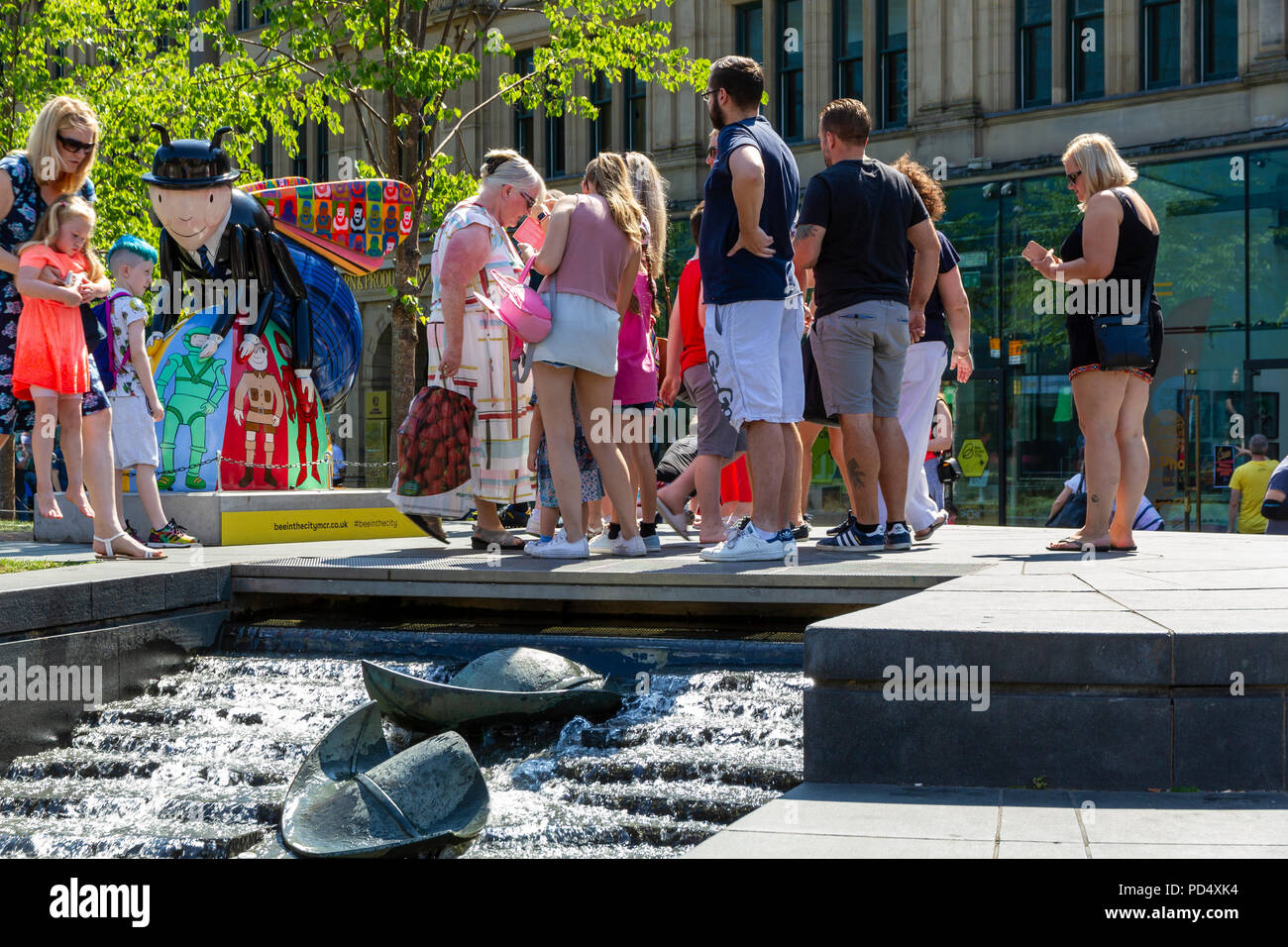 La folla di gente radunata attorno a un APE in Cattedrale Giardini a Manchester Bee Trail Foto Stock