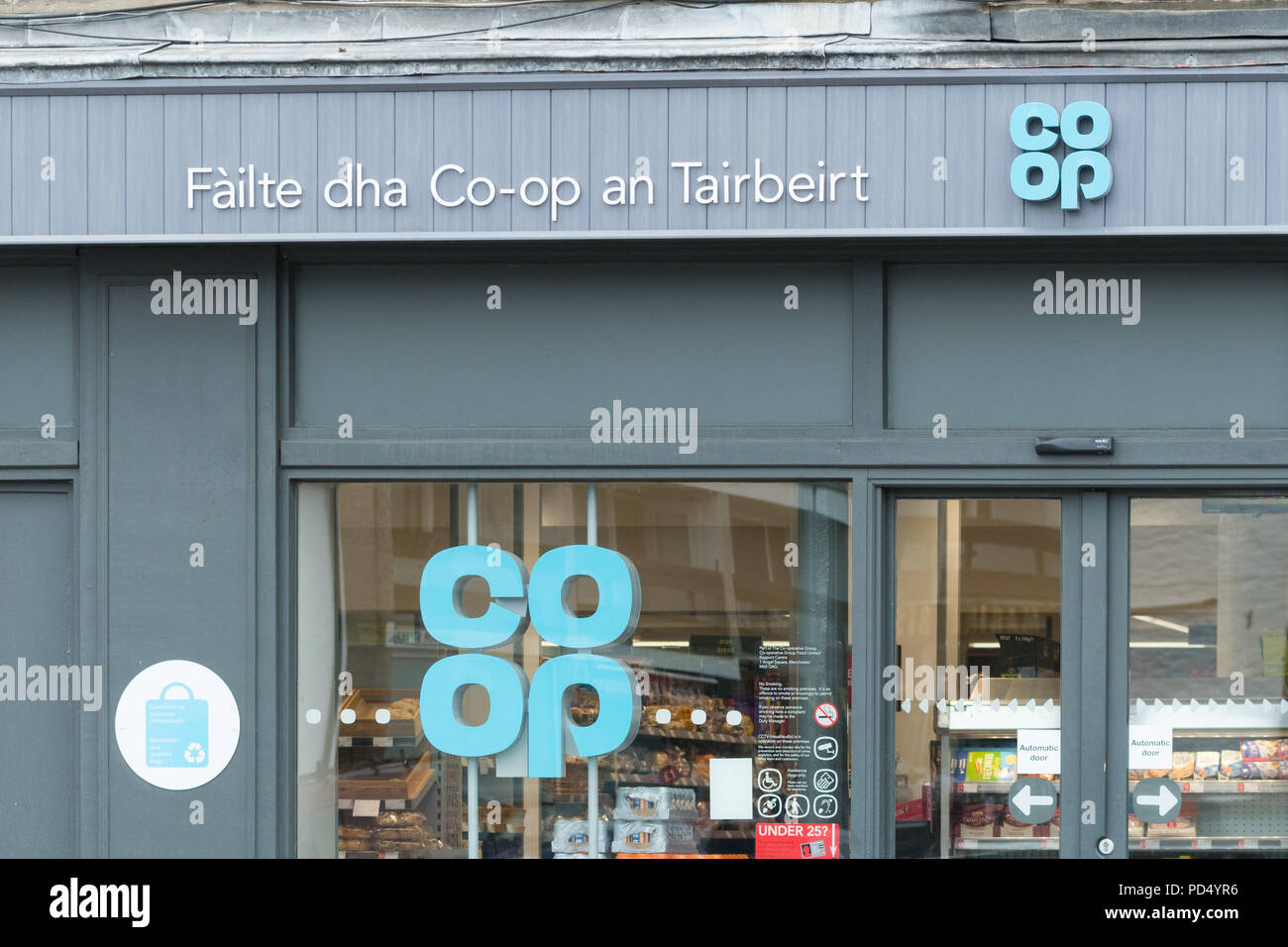Il gaelico scozzese segno sul negozio coop a Tarbert - Failte dha co-op un Tairbeirt - benvenuti al co-op Tarbert, Argyll and Bute, Scotland, Regno Unito Foto Stock