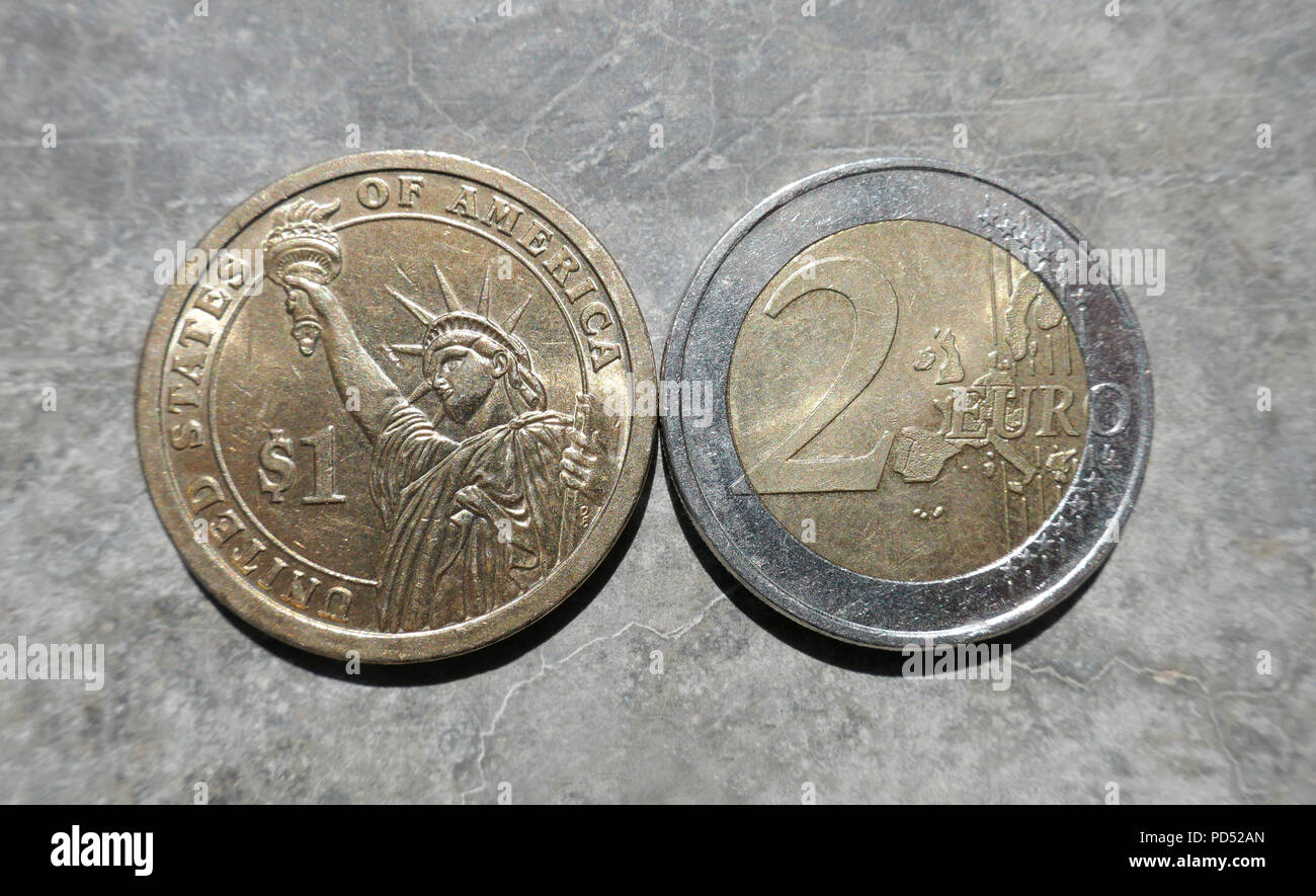 Close up di un dollaro e monete da due Euro moneta Foto Stock