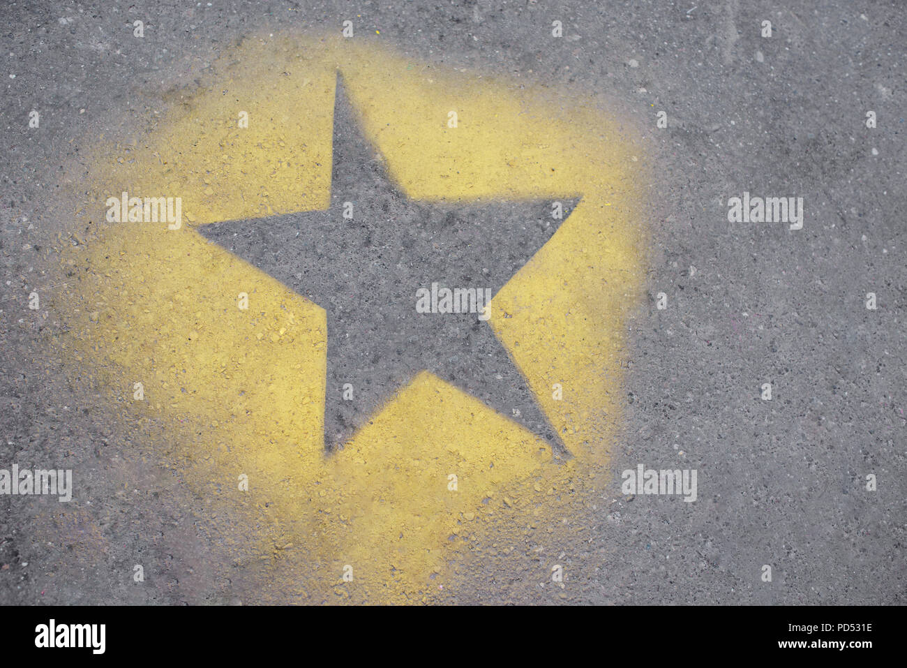 La stella gialla è dipinta su GRIGIO ASFALTO. Foto Stock
