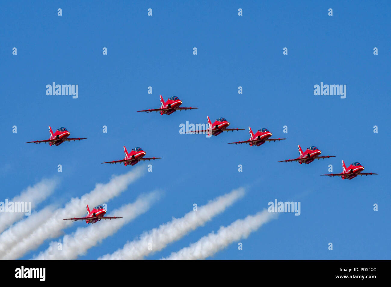 Otto aviogetti Hawk della Royal Air Force Aerobatic Team, le frecce rosse, volare in formazione su Cardiff Galles Aeroporto finale di fumo bianco Foto Stock
