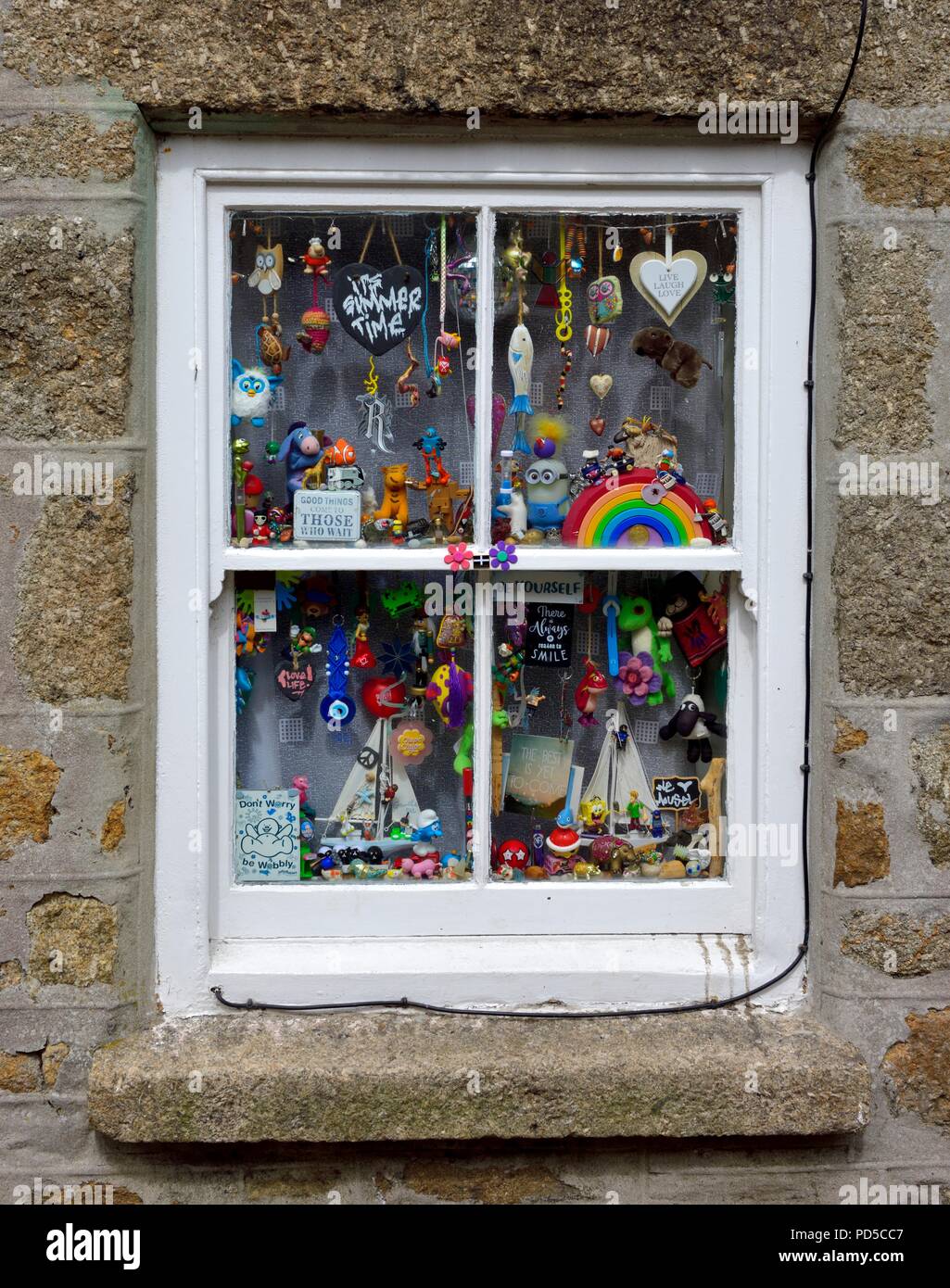 Cottage finestra con vari ornamenti e nic knacks,Mousehole,Cornwall,l'Inghilterra,UK Foto Stock