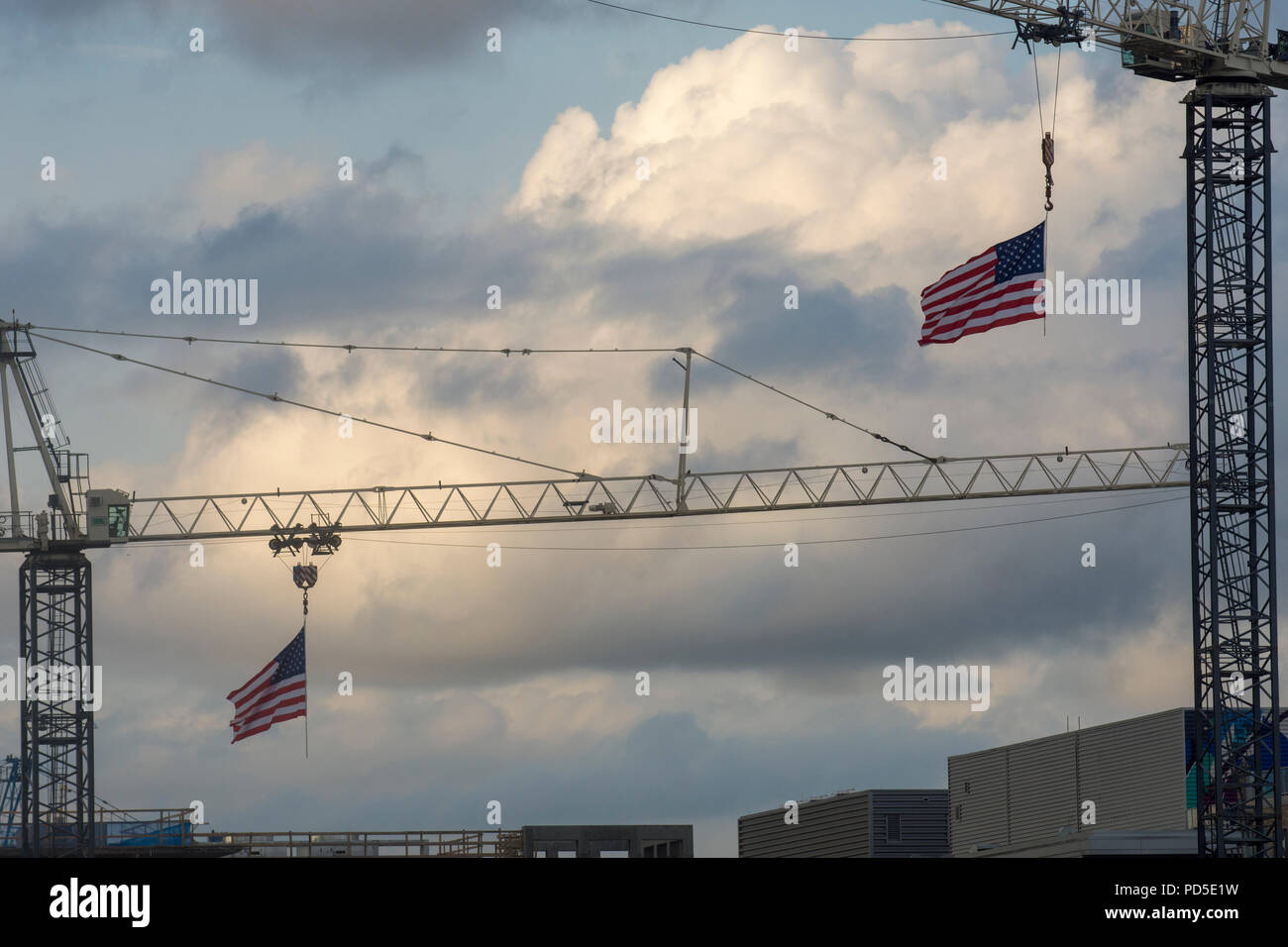 Estate nuvole temporalesche dominano la gru da cantiere decorate con U.S. fllags, visto da cittadini Parco di Washington, DC. Foto Stock