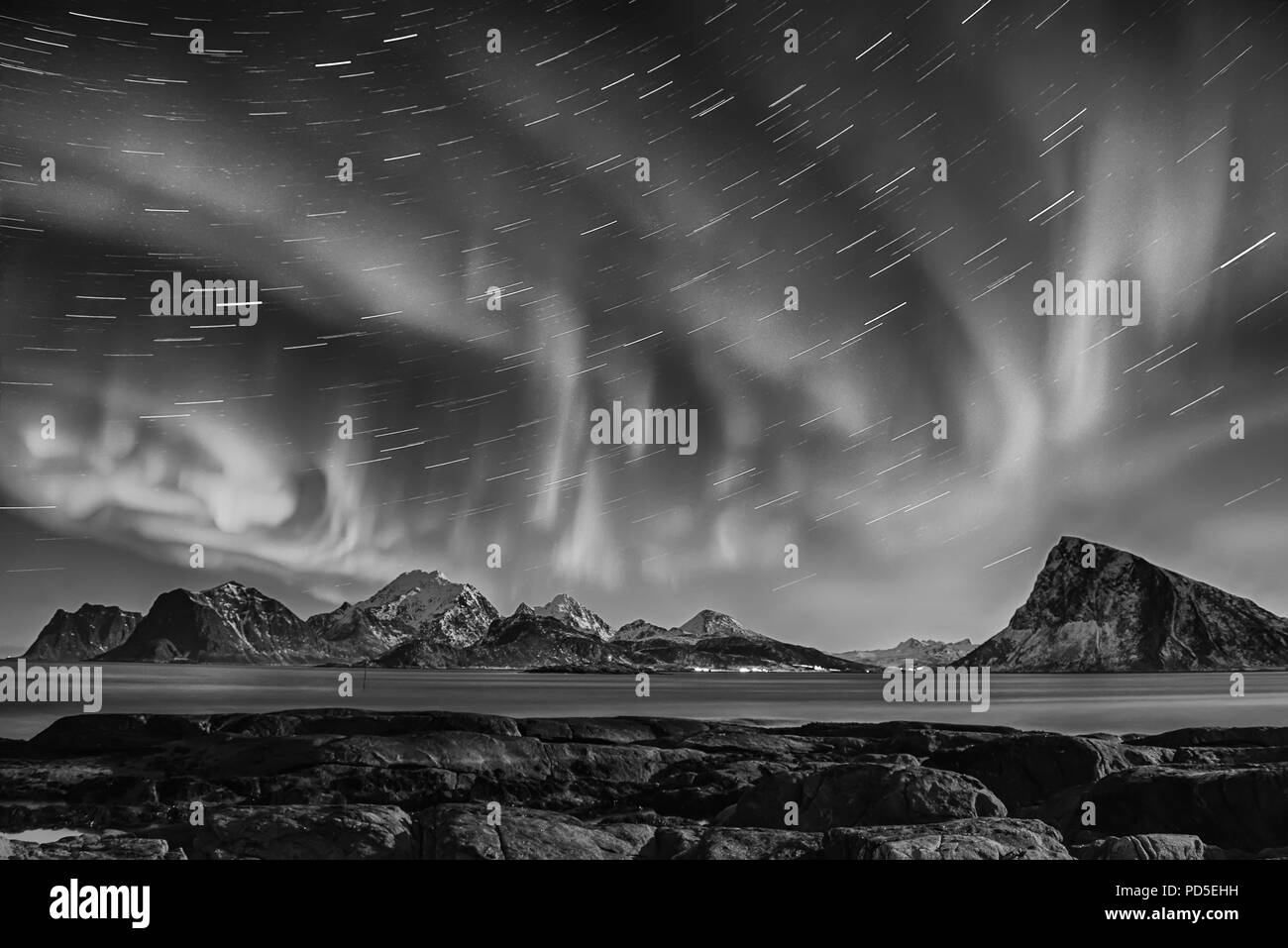 Luci del nord, Aurora Boreale splendente nella notte il cielo stellato con star brani in inverno Isole Lofoten in Norvegia. In bianco e nero. Foto Stock
