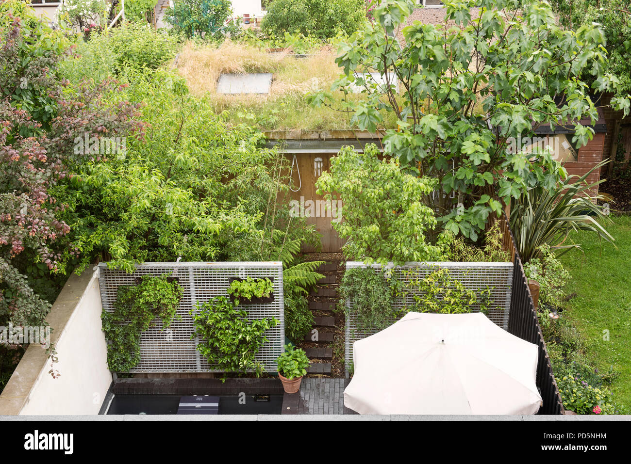 Vista in elevazione di area patio giardino e dipendenza con tetto di erba Foto Stock