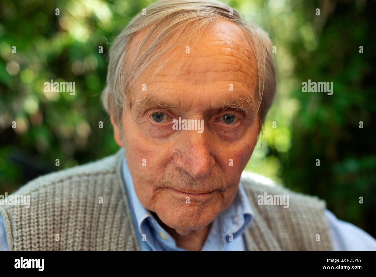 Lonely vecchiaia pensionato seduto nel suo giardino Foto Stock