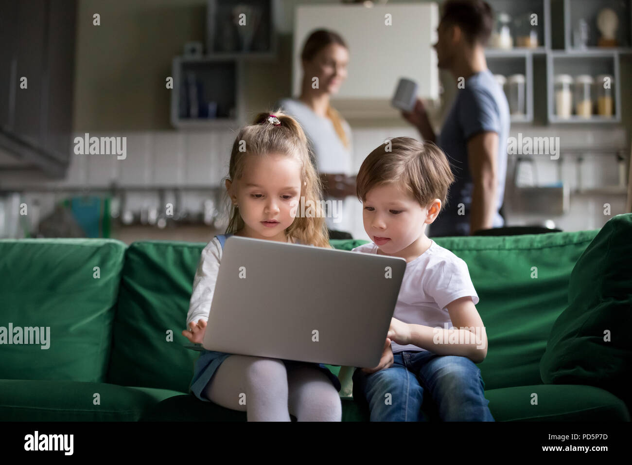 Bambini carino sorella e fratello holding laptop guardare online Foto Stock