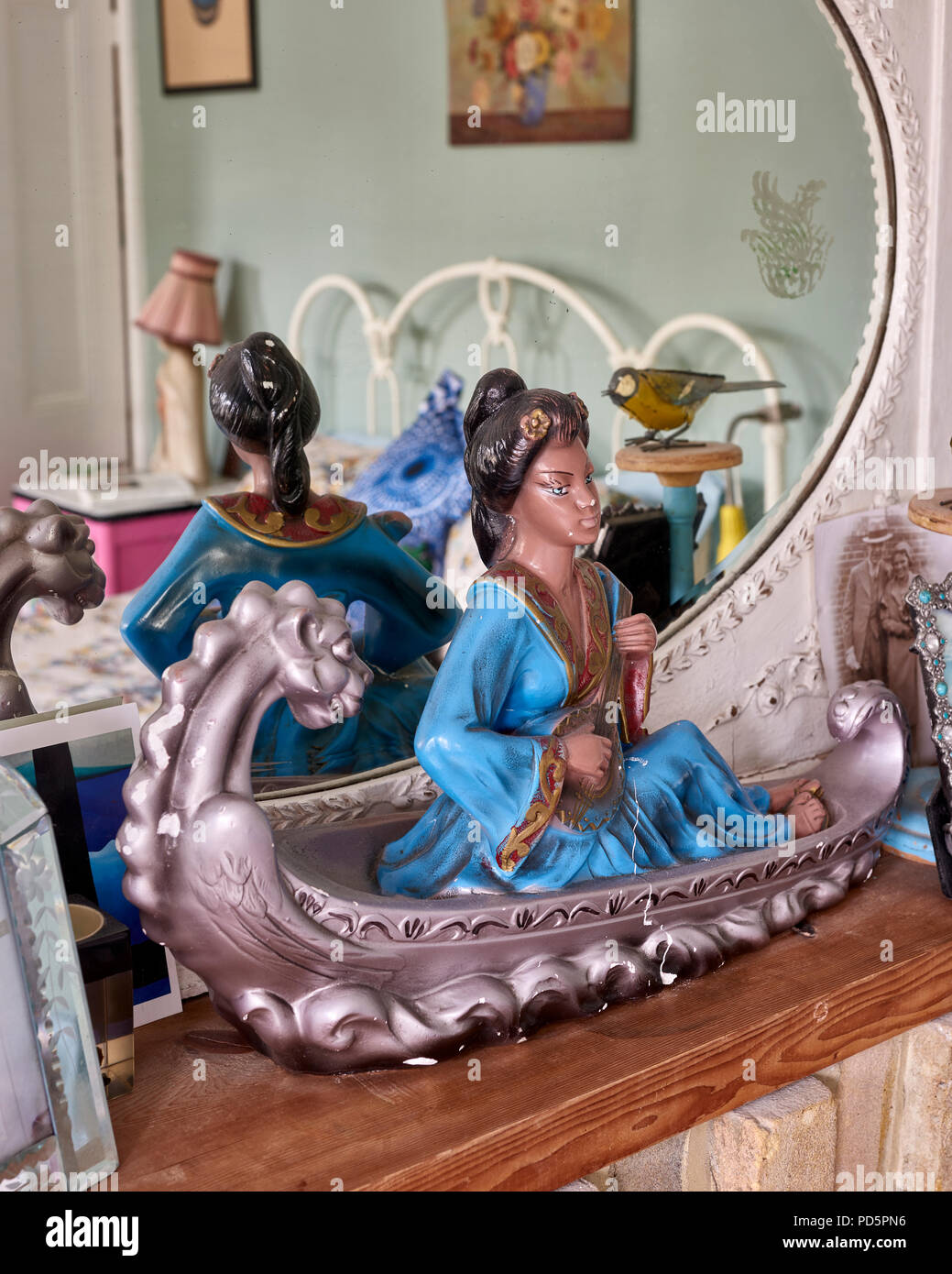 Un kitsch ornamento cinese di una ragazza in un drago canoa Foto Stock