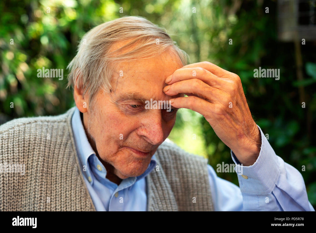 Lonely vecchiaia pensionato seduto nel suo giardino Foto Stock