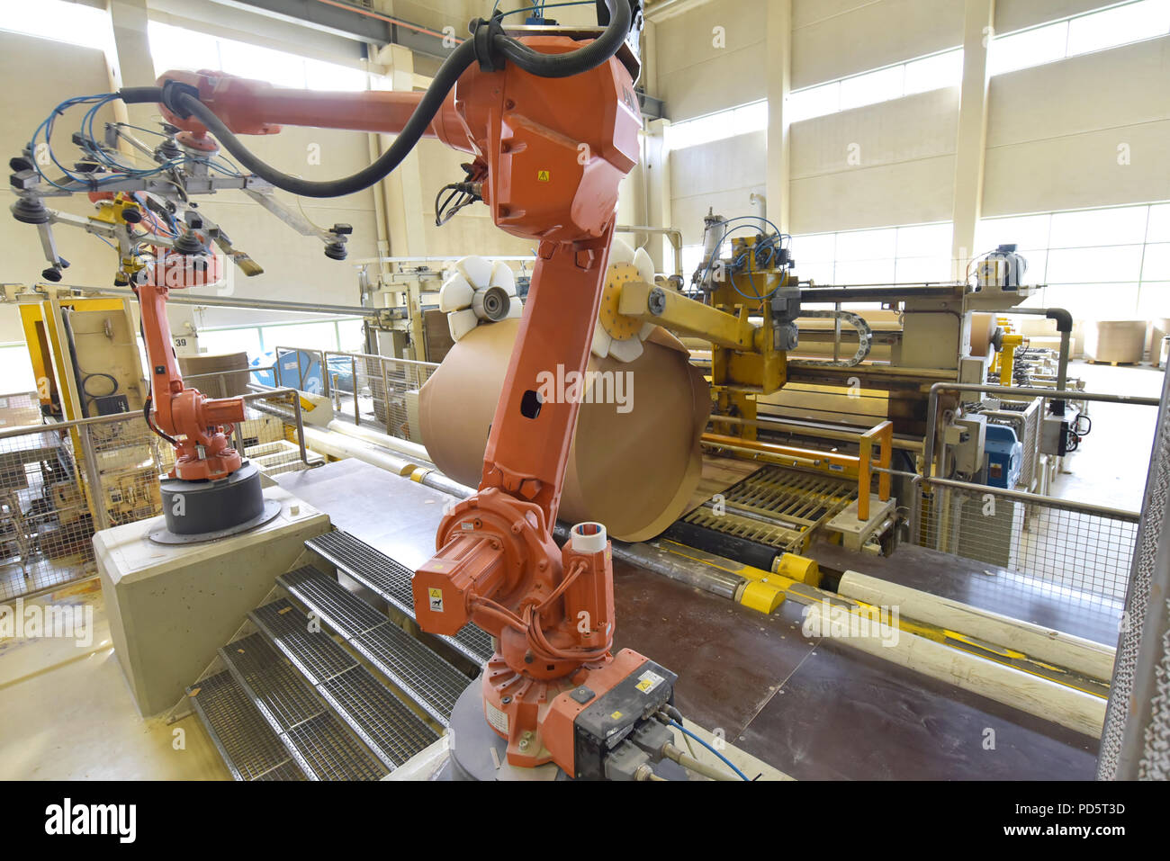 Robot industriale in un mulino di carta - automazione in un impianto moderno - riciclaggio di rifiuti di carta Foto Stock