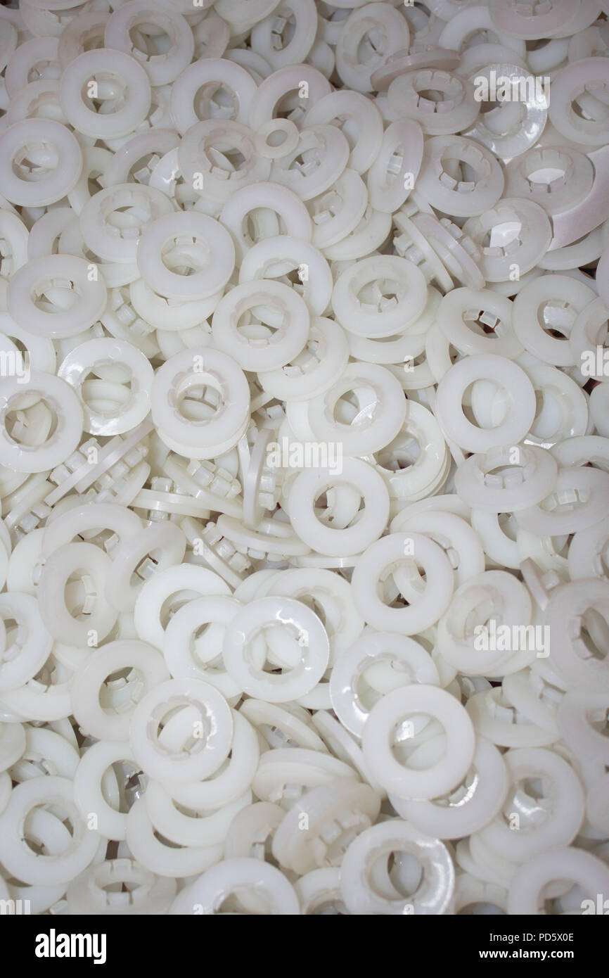 Un sacco di bianca cuscinetti di attrito come parti di un prodotto finale di plastica di industria di produzione Foto Stock
