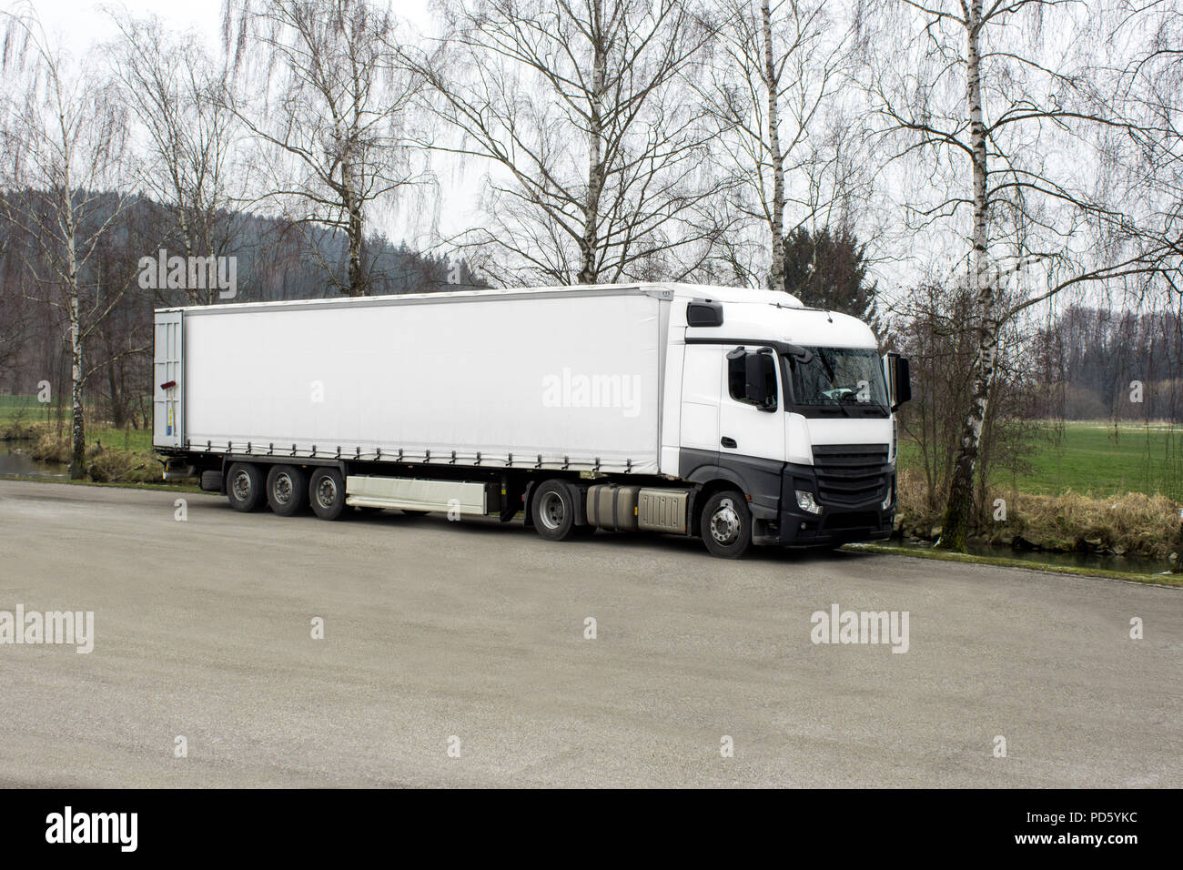 Bianco carrello di trasporto in open space con copyspace per testo europeo trattore rimorchio per il trasporto di merci su strada Foto Stock