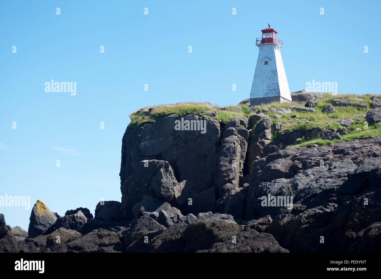 Il bianco e il rosso faro sul bordo di una scogliera (cinghiale Capo Faro, Nova Scotia) Foto Stock