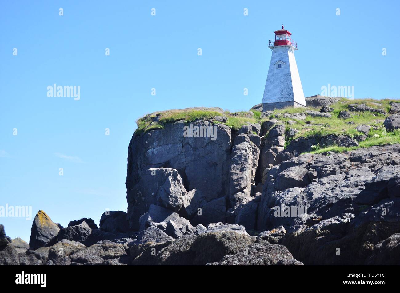 Il bianco e il rosso faro sul bordo di una scogliera (cinghiale Capo Faro, Nova Scotia) Foto Stock