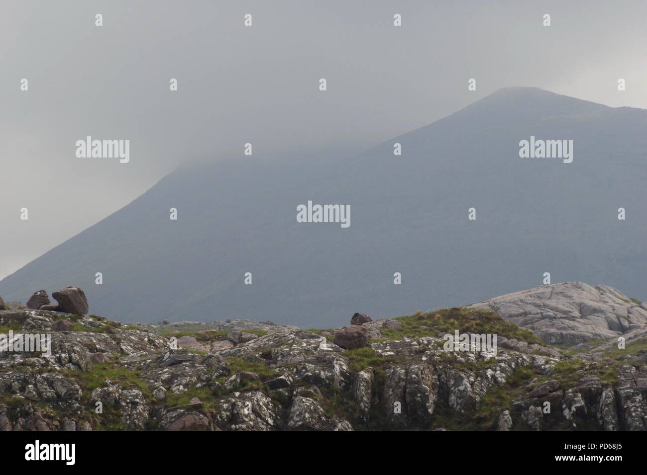 Bassa nube spessa avvolgenti la cima della montagna di Beinn Alligin - Tom na Gruagaich. Torridon, Scotland, Regno Unito. Estate, 2018. Foto Stock