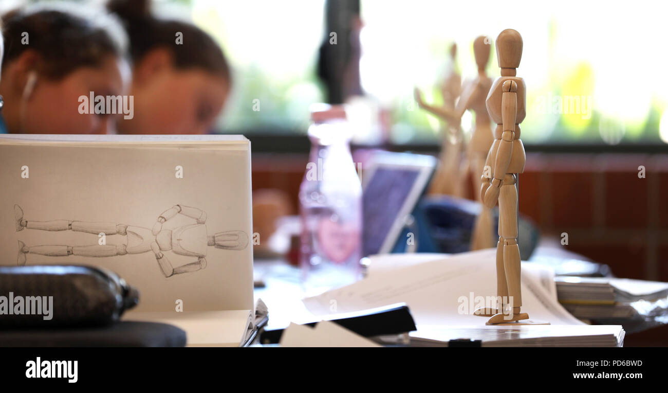 Arte visiva di alta scuola gli studenti lavorano da manichini in legno la pratica di disegno fugurante umana e la proporzione corretta. Gli artisti creativi del settore Foto Stock