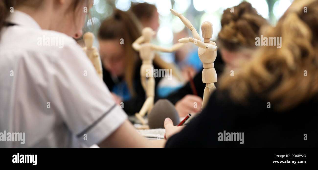 Arte visiva di alta scuola gli studenti lavorano da manichini in legno la pratica di disegno fugurante umana e la proporzione corretta. Gli artisti creativi del settore Foto Stock
