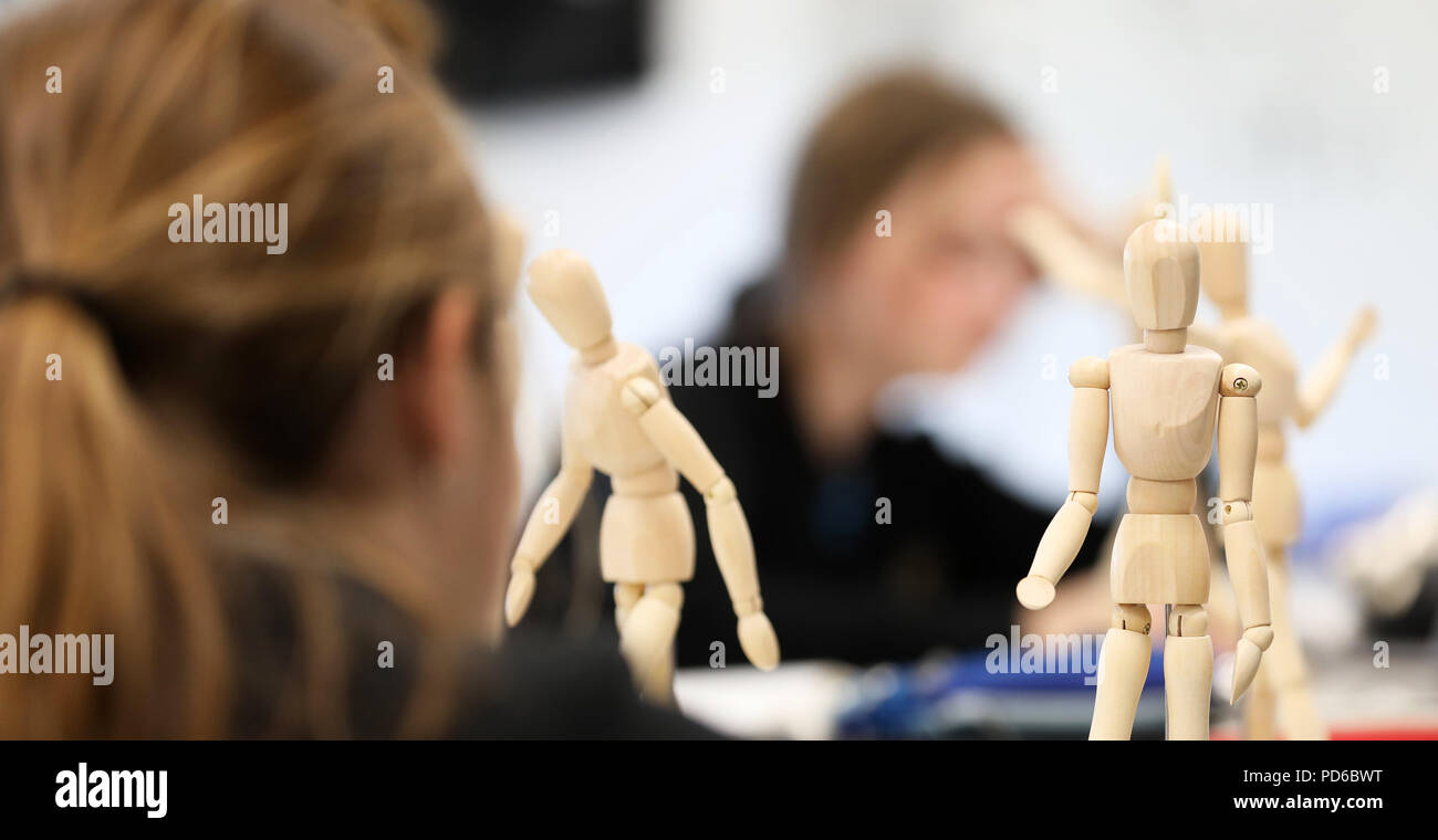 Arte visiva di alta scuola gli studenti lavorano da manichini in legno la pratica di disegno fugurante umana e la proporzione corretta. Gli artisti creativi del settore Foto Stock