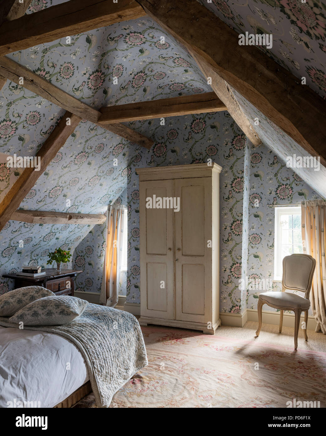Luce blu tappezzato la struttura di legno mansarda camera da letto con guardaroba di crema Foto Stock