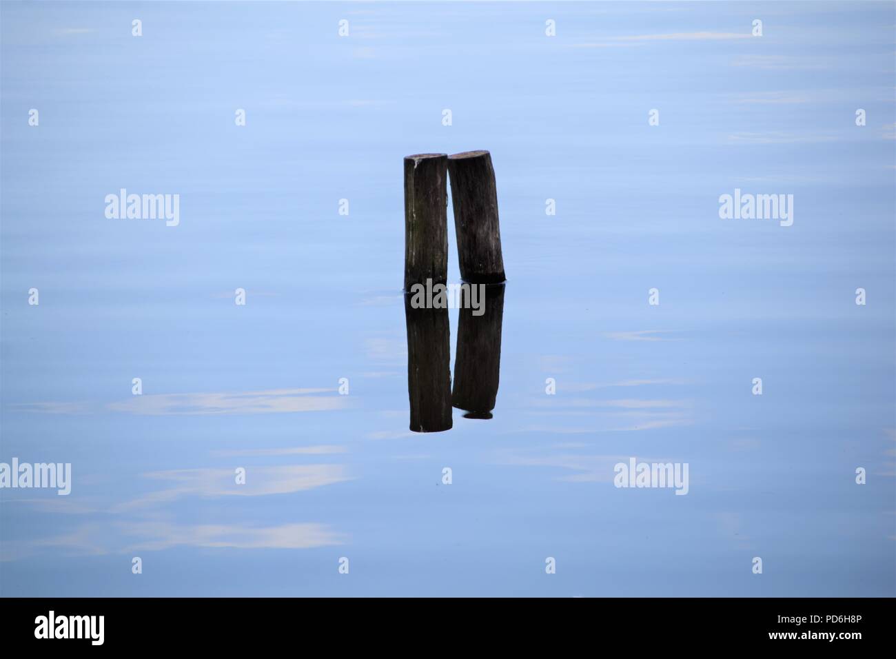La riflessione di due bastoni di legno in acqua Foto Stock