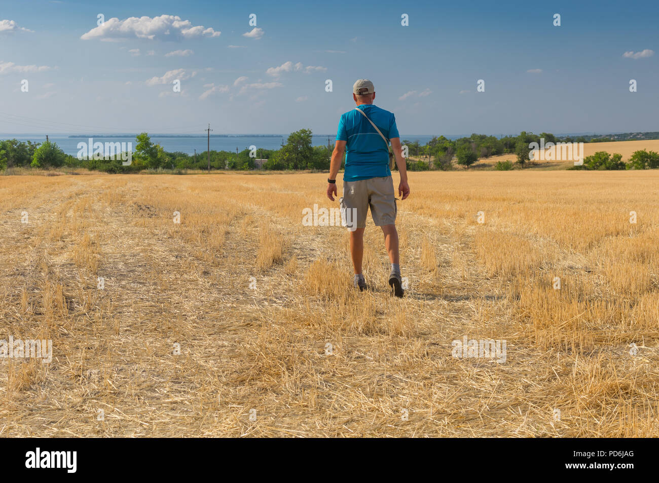 Coppia escursionista voce per il Dnipro river attraverso raccolte campo di grano in Ucraina Foto Stock