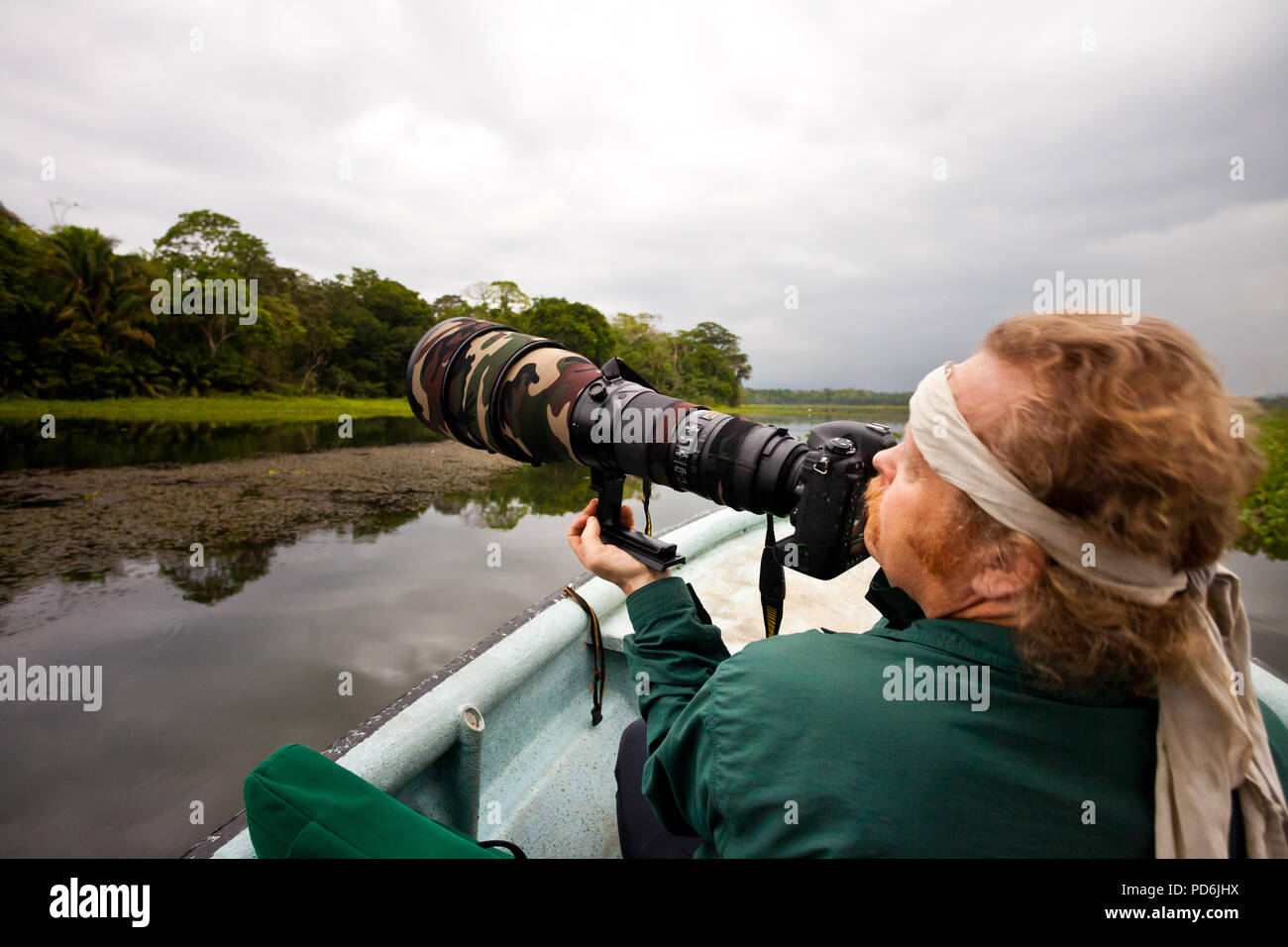 Wildlife Photographer con grande un teleobiettivo in una barca sul Rio Chagres, parco nazionale di Soberania, Repubblica di Panama. Foto Stock