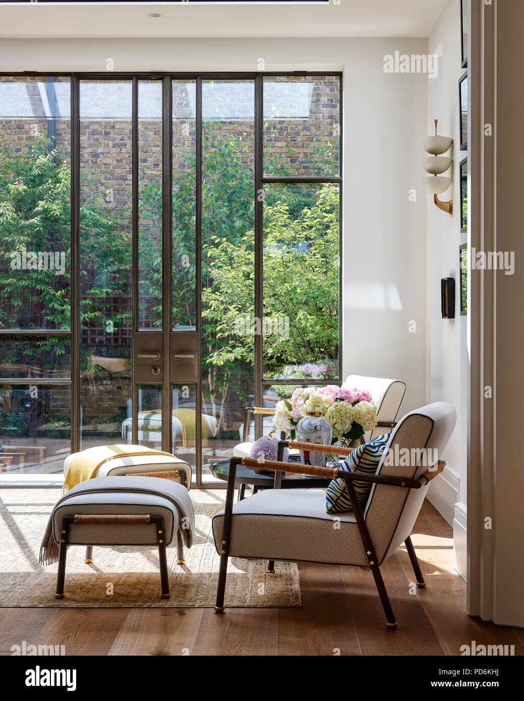 Sedie vintage e footstools a grande altezza doppia finestra con porta. Foto Stock