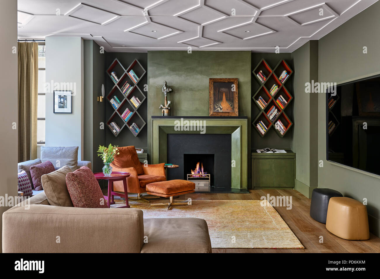 Vintage poltrona e poggiapiedi withlit fire e montato a parete a scaffali Foto Stock