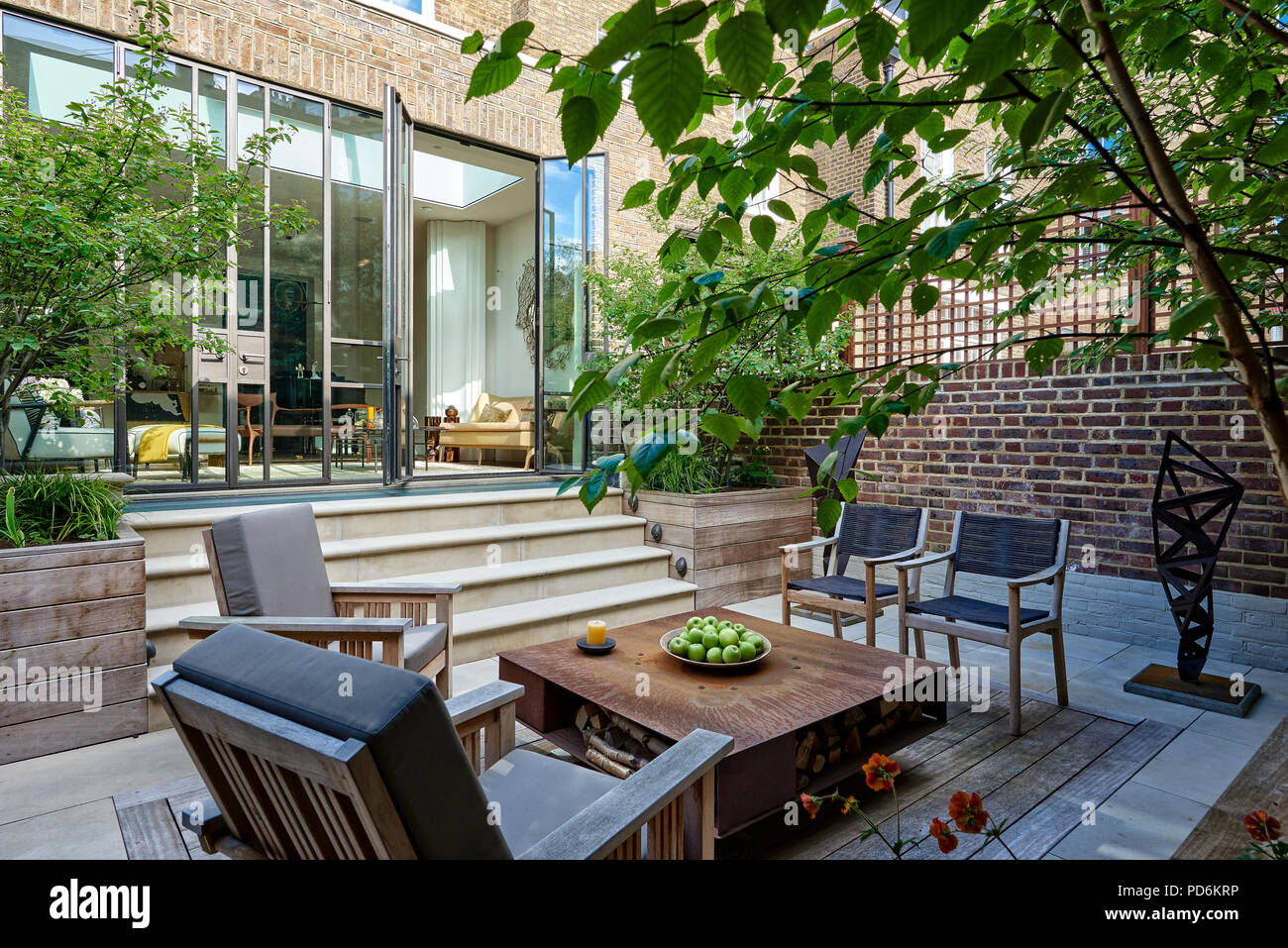 Area con posti a sedere e tavolo da caffè in giardino nel cortile di Londra nel periodo Vittoriano home Foto Stock