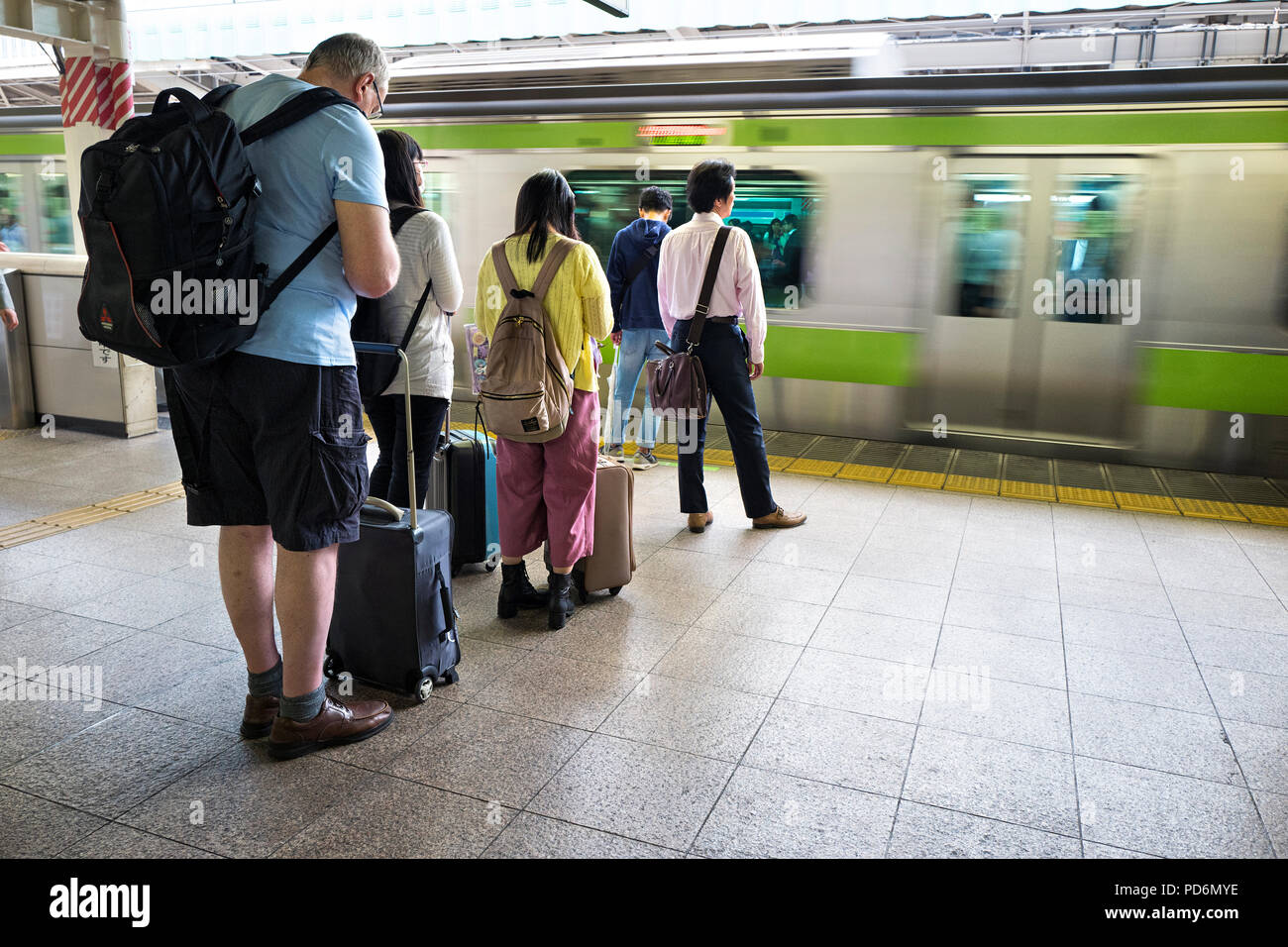 Giappone, isola di Honshu, Kanto, Tokyo, persone waitng un treno su una piattaforma. Foto Stock