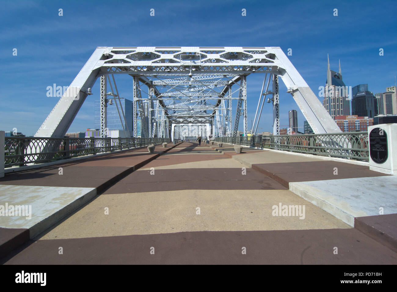 Una vista del centro di Nashville, Tennessee skyline da John Seigenthaler ponte pedonale. Il ponte di travatura reticolare attraversa il Cumberland River. Foto Stock
