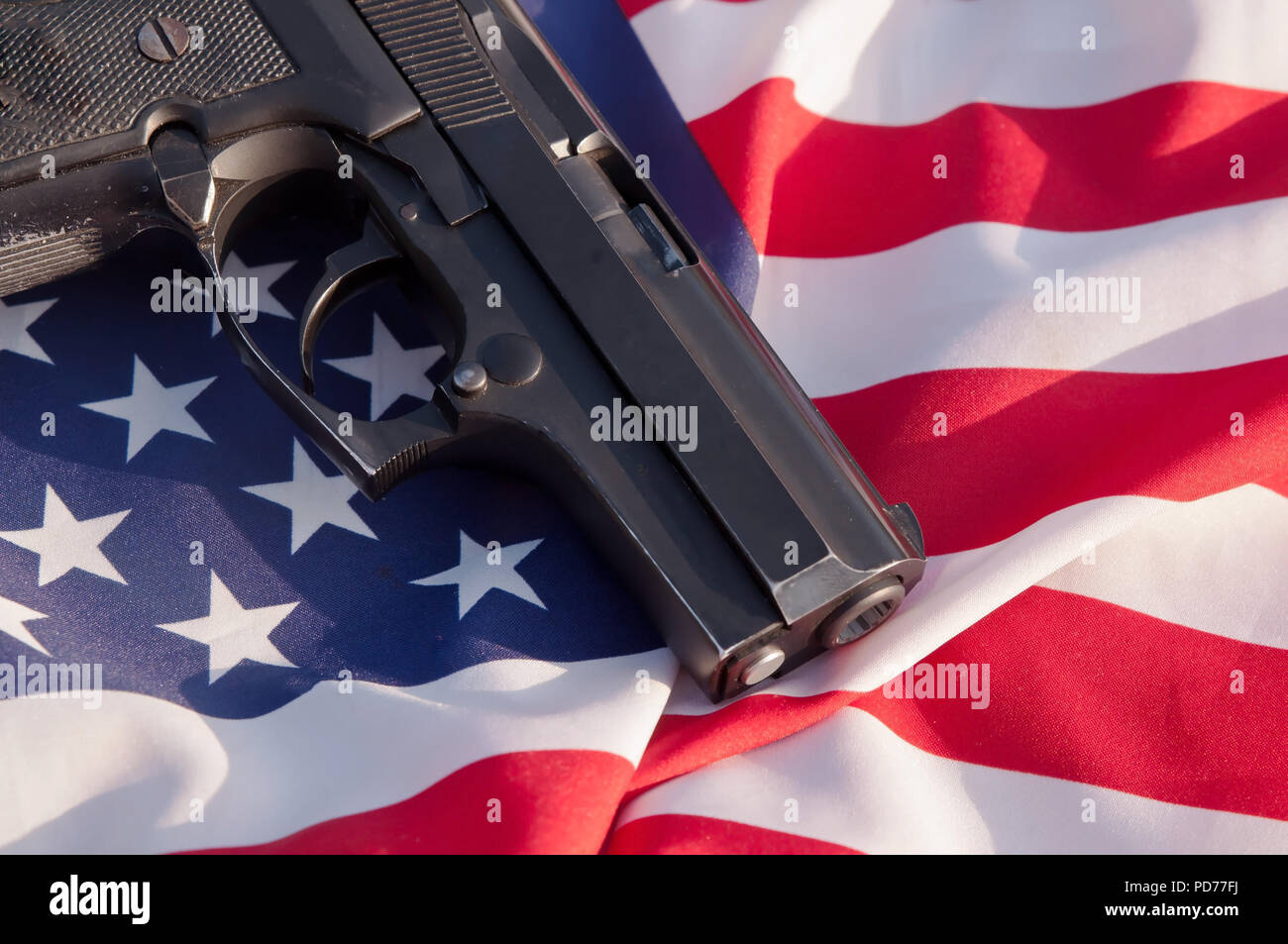 Una pistola nero mostrato posa su una bandiera americana Foto Stock